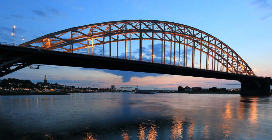 Waalbrug in Nijmegen bij zonsondergang, sfeervolle achtergrond van Blue Fit
